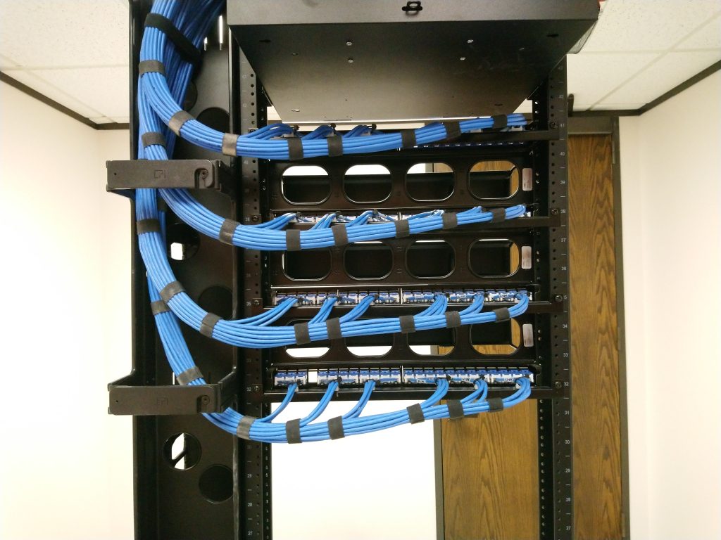 Cable dressed in to rear of patch panels secured with hook and loop